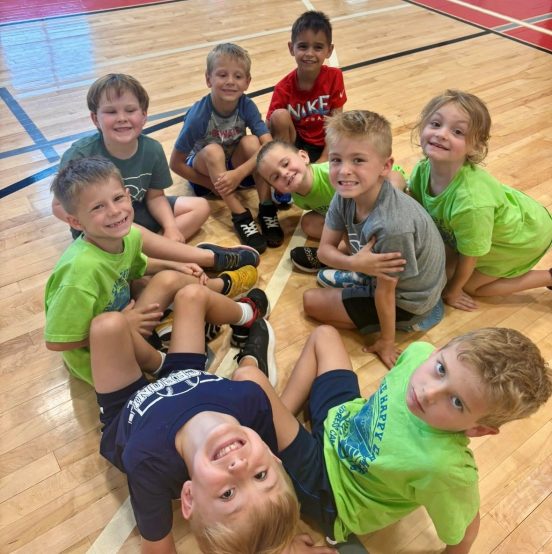 Kids sitting on the floor smiling at camera